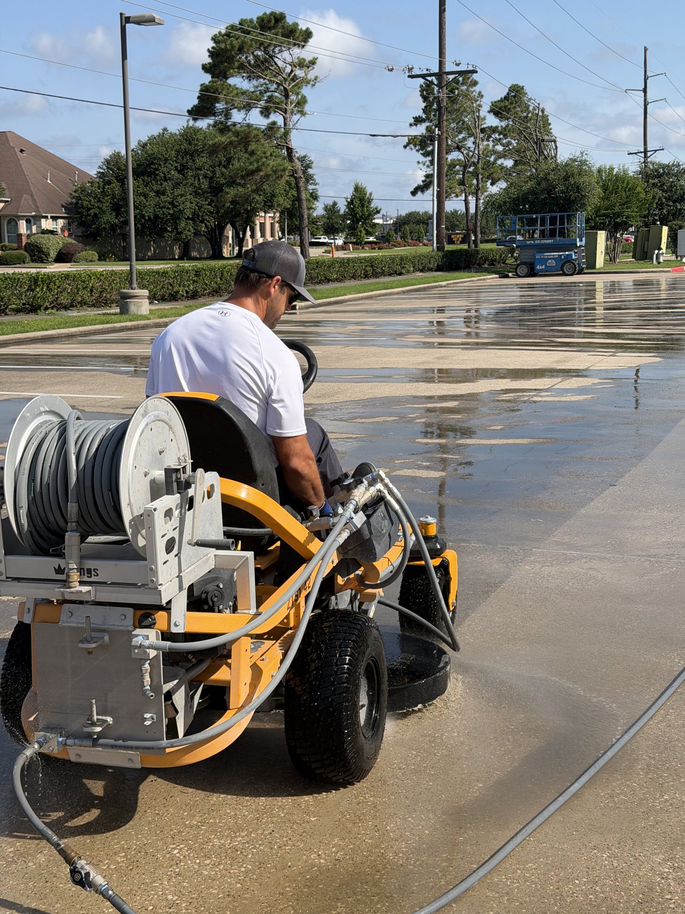 The Beast ride-on pressure washer cleaning a large commercial parking lot in Southeast Texas